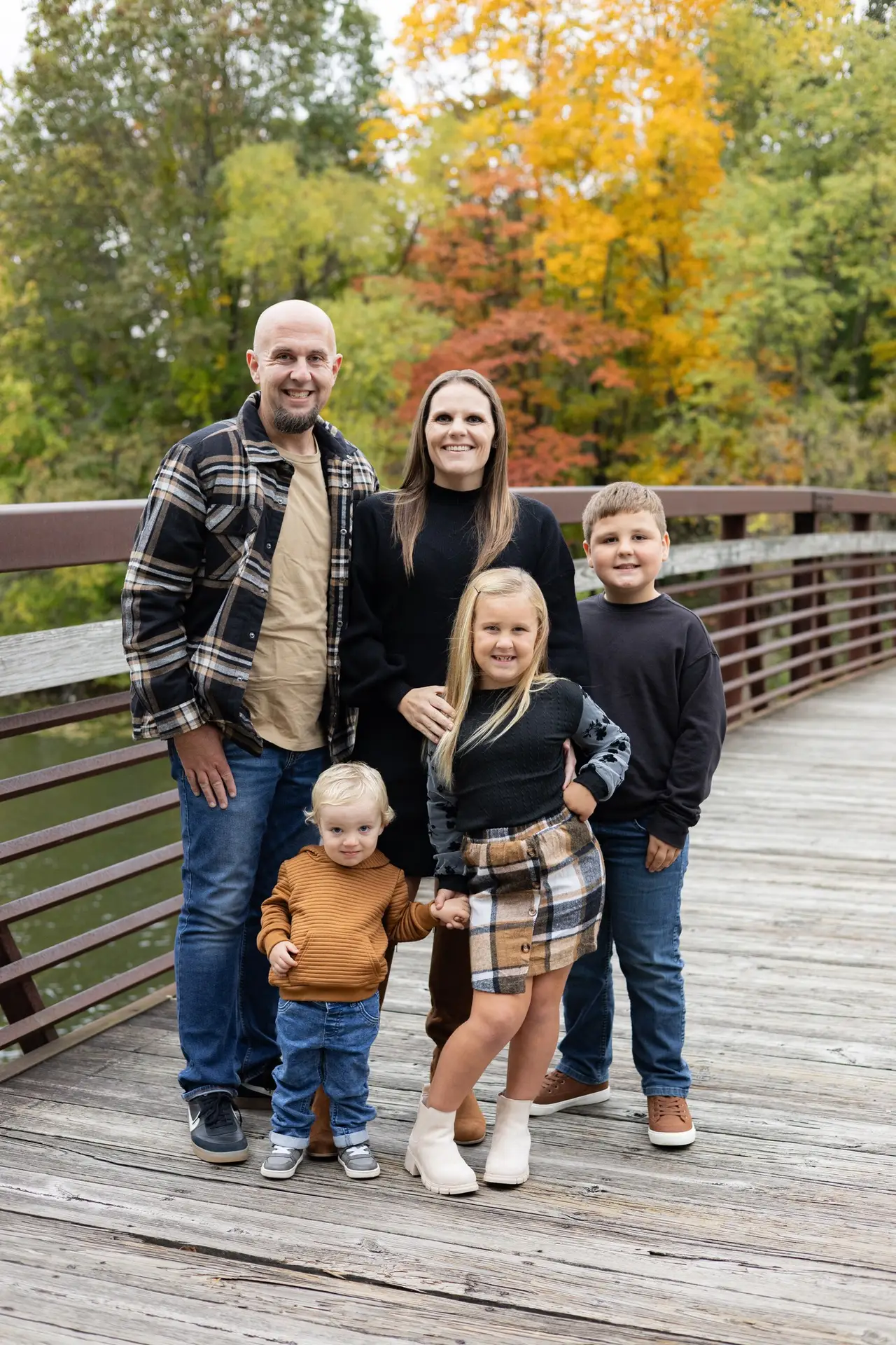 family of five posing for a photo on a bridge
