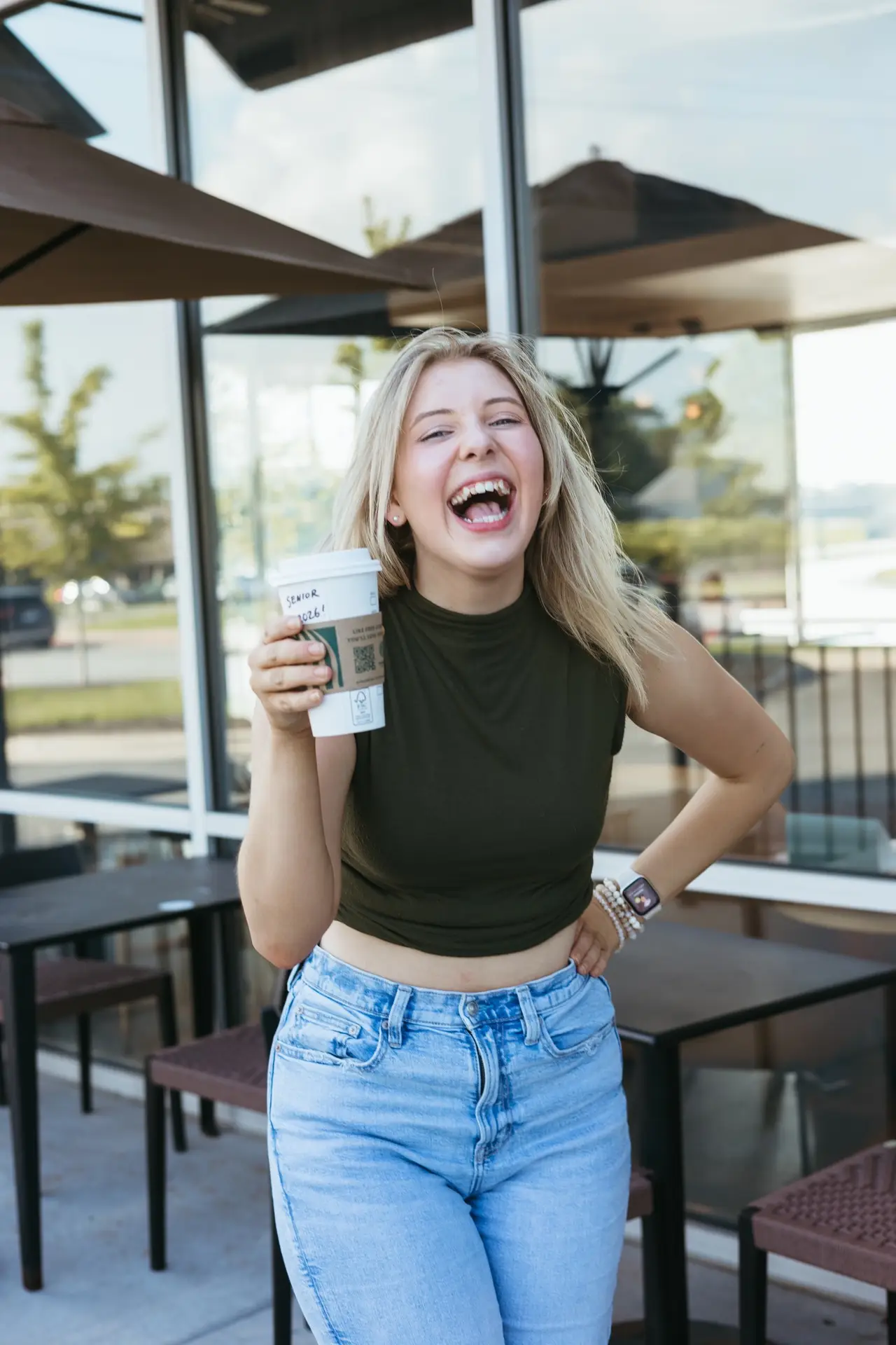 woman posing in front of Starbucks with a coffee cup